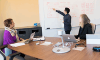 A group of office colleagues training about the benefits of a Knowledge Management System